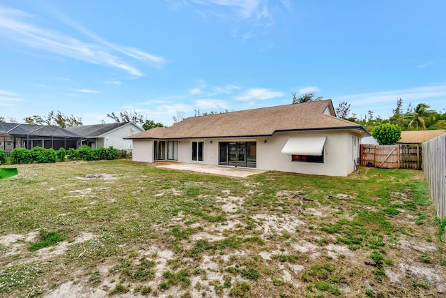 back of house featuring a yard, a fenced backyard, a patio, and stucco siding