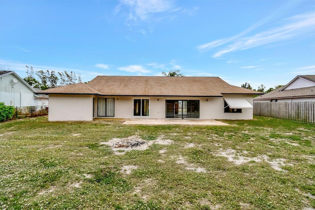 rear view of property with a yard, a fenced backyard, stucco siding, and a patio