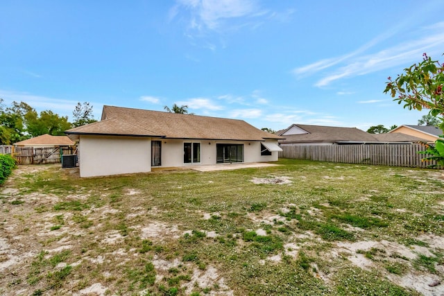 back of house with a lawn, a patio area, a fenced backyard, and stucco siding