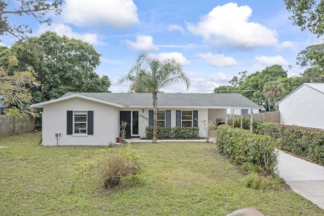 ranch-style house featuring a front lawn, fence, and stucco siding