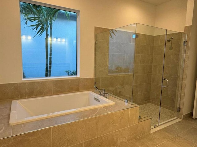 bathroom with a garden tub, tile patterned flooring, and a shower stall