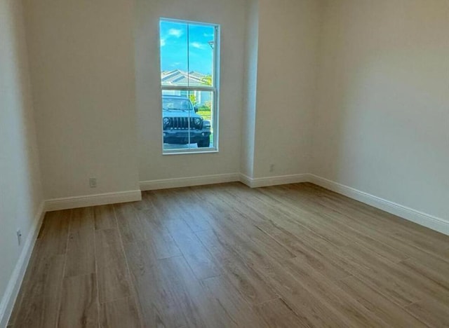 unfurnished room featuring light wood finished floors and baseboards