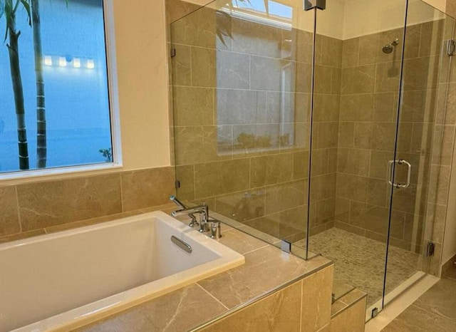 bathroom featuring a garden tub and a shower stall