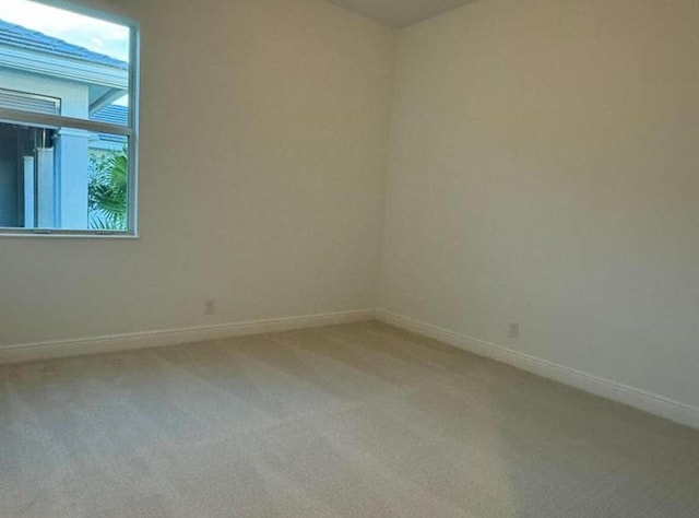 carpeted empty room with baseboards