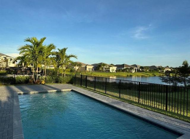 view of pool with a water view, a fenced backyard, and a residential view