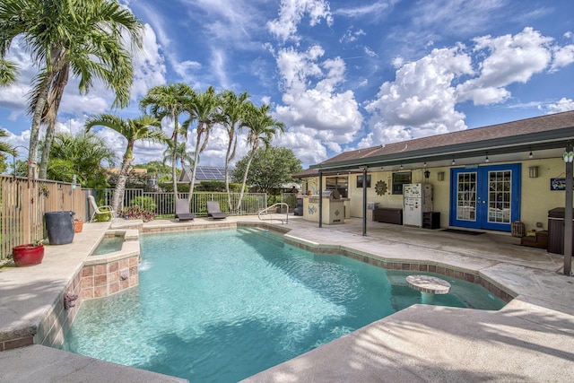 view of swimming pool with a fenced in pool, french doors, a patio, a fenced backyard, and a jacuzzi