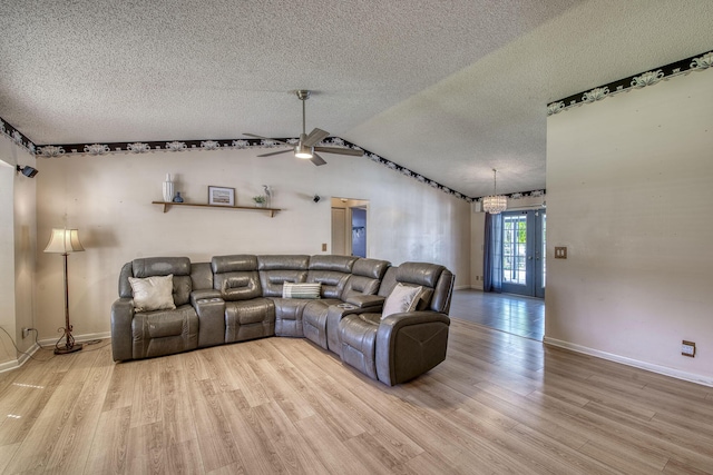 living area featuring light wood-type flooring, vaulted ceiling, and a textured ceiling