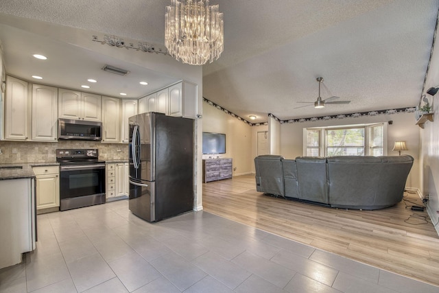 kitchen featuring lofted ceiling, stainless steel appliances, decorative backsplash, and open floor plan