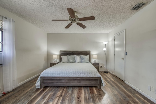 bedroom featuring visible vents, ceiling fan, a textured ceiling, wood finished floors, and baseboards