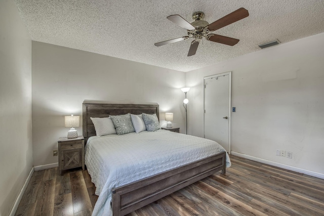 bedroom featuring a textured ceiling, wood finished floors, baseboards, and ceiling fan