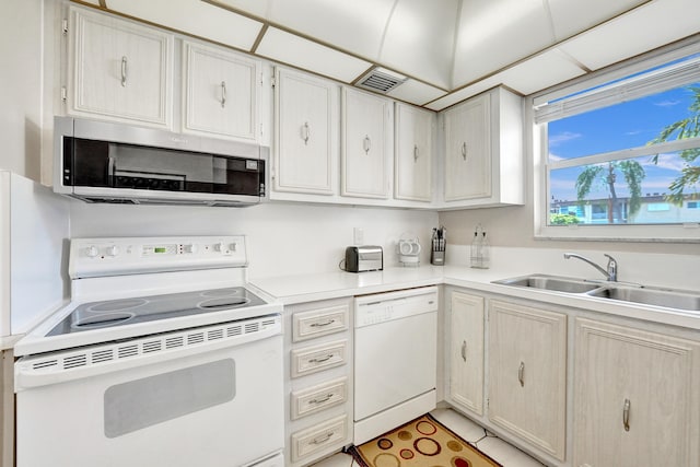 kitchen featuring white appliances, visible vents, light countertops, and a sink