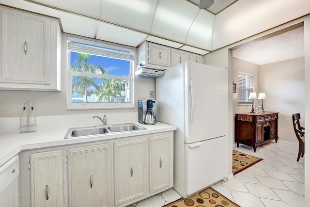 kitchen featuring light countertops, white appliances, plenty of natural light, and a sink