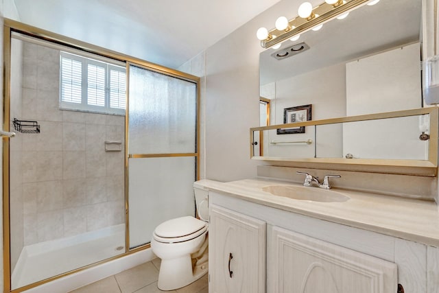 full bath featuring toilet, vanity, a tile shower, and tile patterned floors