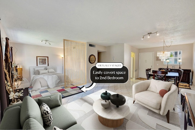 living room featuring light tile patterned floors, visible vents, a textured ceiling, a chandelier, and track lighting