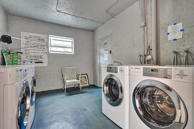 community laundry room featuring a textured wall and washer and clothes dryer