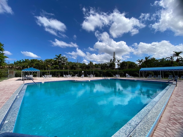 community pool featuring fence and a patio