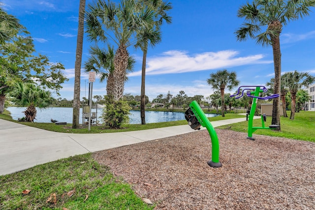 view of playground with a water view and a lawn