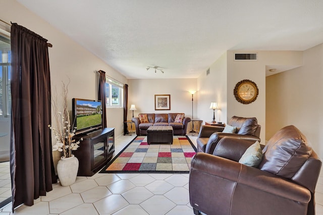 living room with track lighting, visible vents, and a textured ceiling