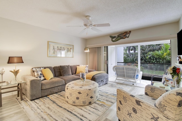 living room with a textured ceiling, wood finished floors, and a ceiling fan