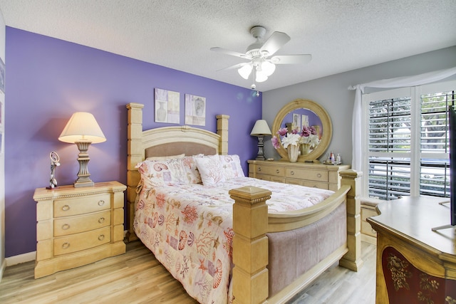 bedroom featuring a textured ceiling, ceiling fan, and light wood-style floors