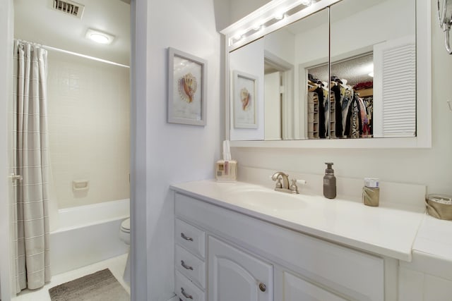 bathroom featuring visible vents, toilet, a walk in closet, shower / bath combination with curtain, and vanity