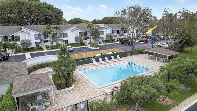 pool with a patio area, a residential view, fence, and a gazebo