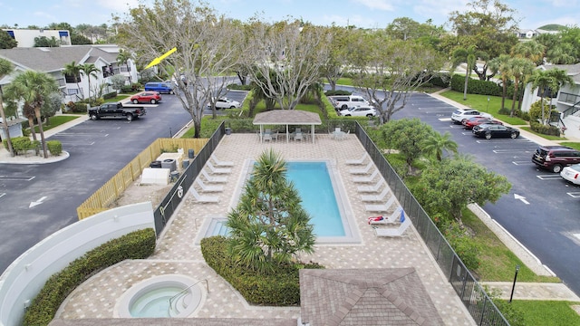 community pool with a residential view, fence, a community hot tub, and a gazebo