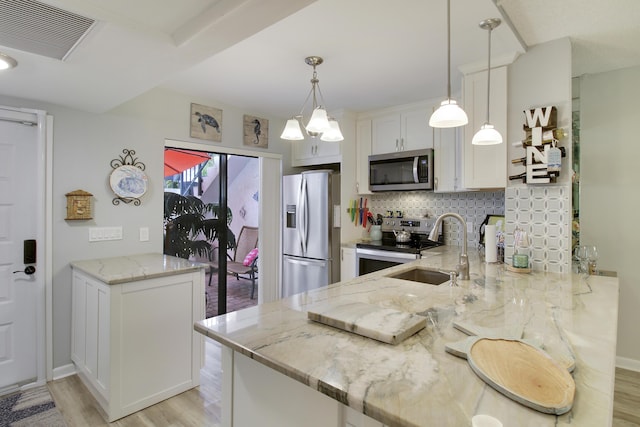 kitchen featuring a sink, visible vents, appliances with stainless steel finishes, light wood-type flooring, and tasteful backsplash