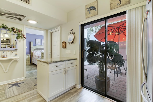 entryway with visible vents, light wood-style flooring, and baseboards