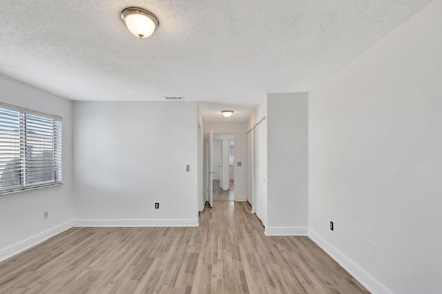 5598 Pebble Brook Ln, Boynton Beach, FL 33472 - spare room featuring light wood-type flooring, visible vents, a textured ceiling, and baseboards