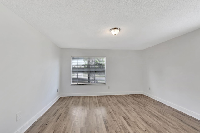 5598 Pebble Brook Ln, Boynton Beach, FL 33472 - empty room with light wood-style flooring, baseboards, and a textured ceiling