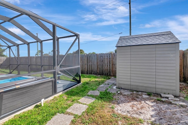 5598 Pebble Brook Ln, Boynton Beach, FL 33472 - view of yard featuring a lanai, a fenced backyard, an outdoor structure, and a shed