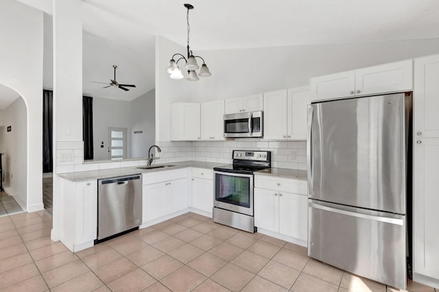 5598 Pebble Brook Ln, Boynton Beach, FL 33472 - kitchen with appliances with stainless steel finishes, vaulted ceiling, white cabinetry, and a sink