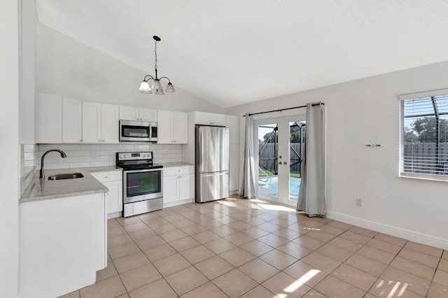 5598 Pebble Brook Ln, Boynton Beach, FL 33472 - kitchen with hanging light fixtures, white cabinetry, stainless steel appliances, and a sink