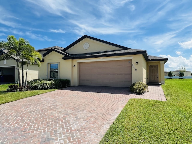 single story home featuring a garage, decorative driveway, a front yard, and stucco siding