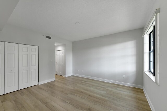 6705 Coral Lake Dr Unit 6705, Margate, FL 33063 - unfurnished bedroom with light wood finished floors, baseboards, and two closets