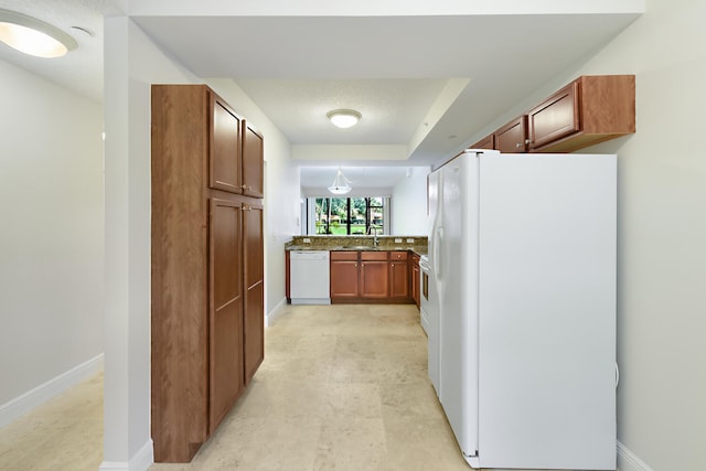 6705 Coral Lake Dr Unit 6705, Margate, FL 33063 - kitchen with white appliances, a sink, brown cabinetry, and baseboards