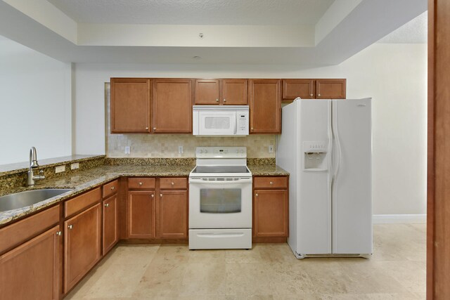 6705 Coral Lake Dr Unit 6705, Margate, FL 33063 - kitchen with white appliances, a sink, dark stone countertops, and brown cabinetry