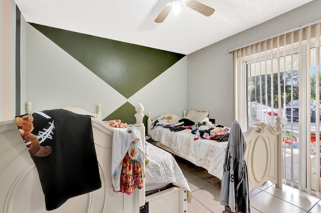 bedroom with a textured ceiling, a ceiling fan, and tile patterned floors