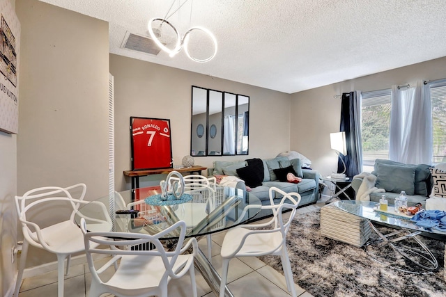 dining room featuring visible vents, a textured ceiling, and light tile patterned flooring