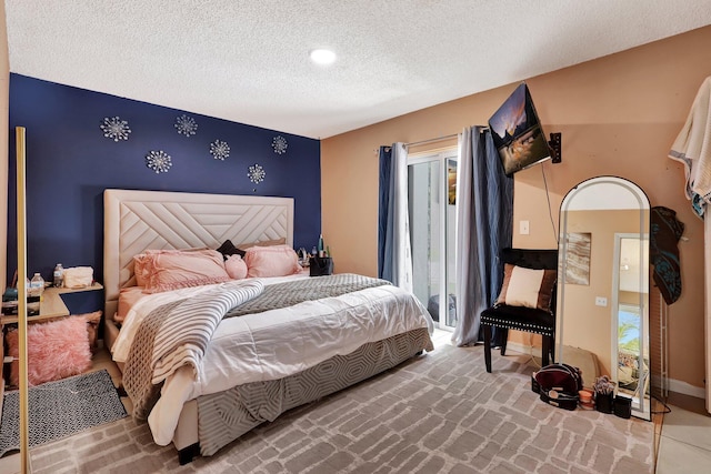 bedroom featuring arched walkways, an accent wall, a textured ceiling, access to outside, and baseboards