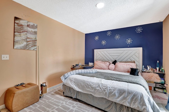 bedroom with a textured ceiling and baseboards