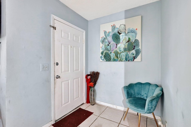 doorway to outside featuring light tile patterned floors and baseboards