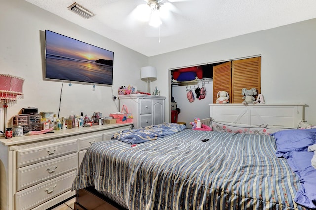 bedroom featuring a textured ceiling, ceiling fan, a closet, and visible vents