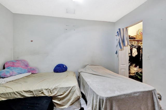 bedroom featuring visible vents, a walk in closet, and a closet