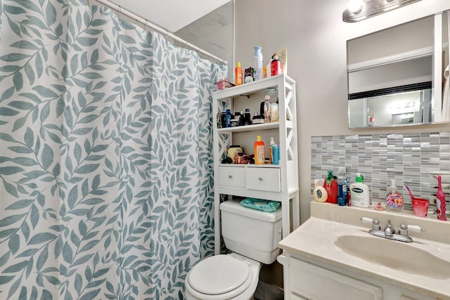 bathroom with toilet, vanity, and decorative backsplash