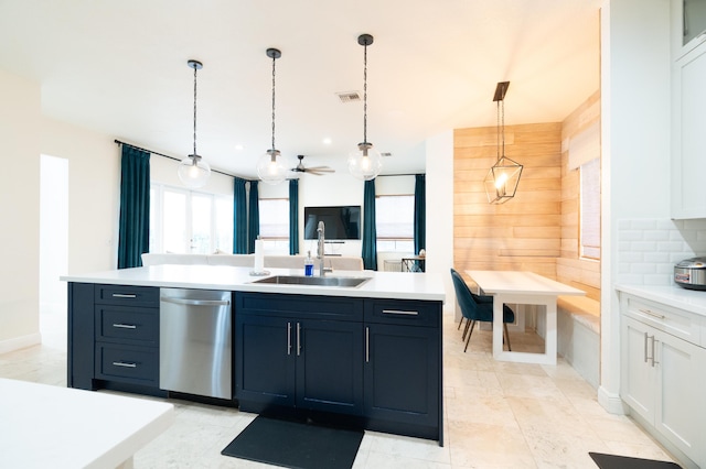 kitchen with light countertops, stainless steel dishwasher, and a sink