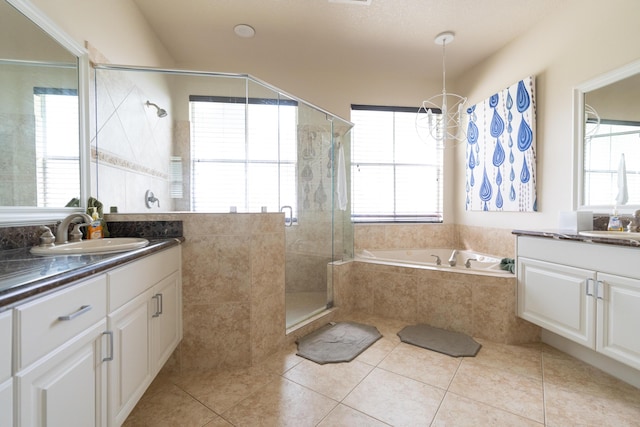 full bathroom with a stall shower, tile patterned flooring, two vanities, and a sink