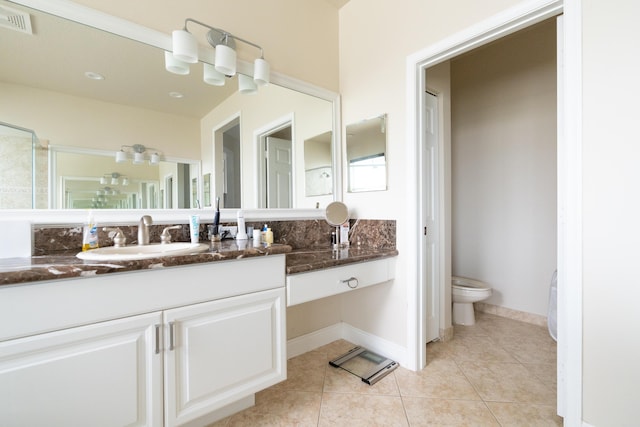 bathroom featuring visible vents, toilet, vanity, tile patterned flooring, and baseboards