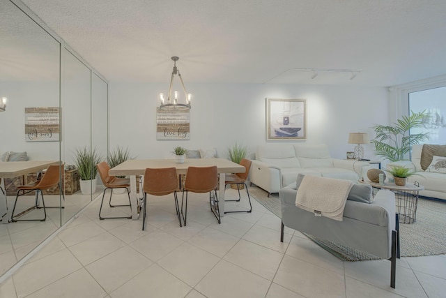 dining room featuring a chandelier, a textured ceiling, light tile patterned flooring, and track lighting